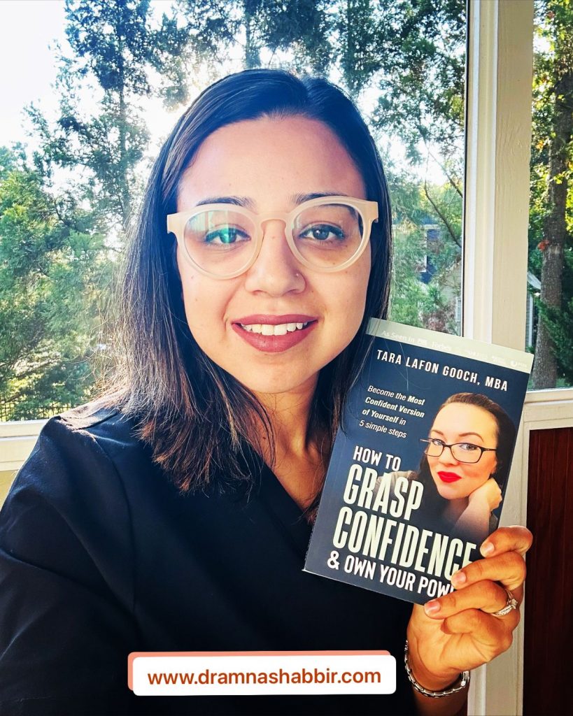 Dr. Amna Shabbir holding up a copy of Tara's book