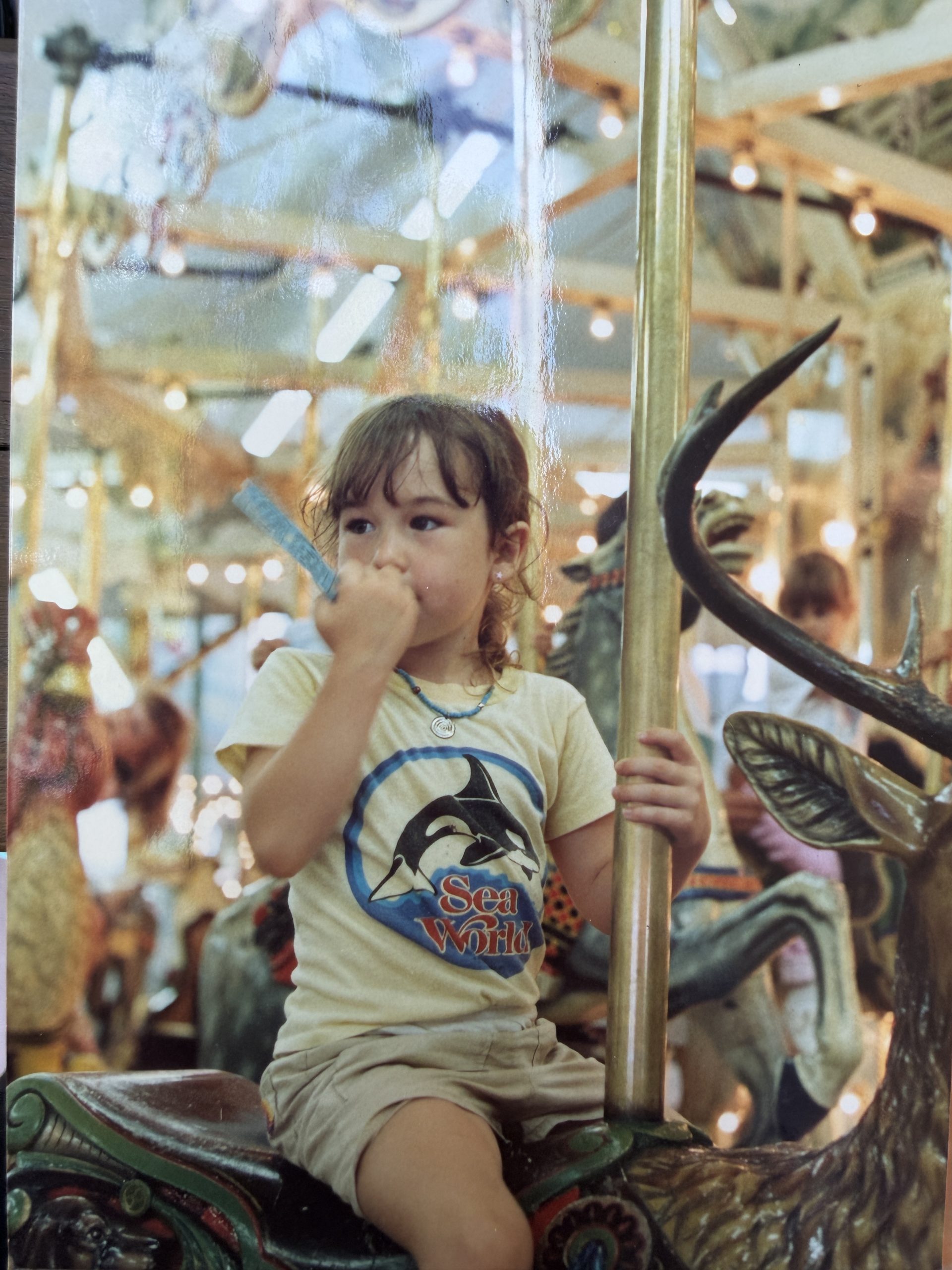 Tara as a young girl on a carousel