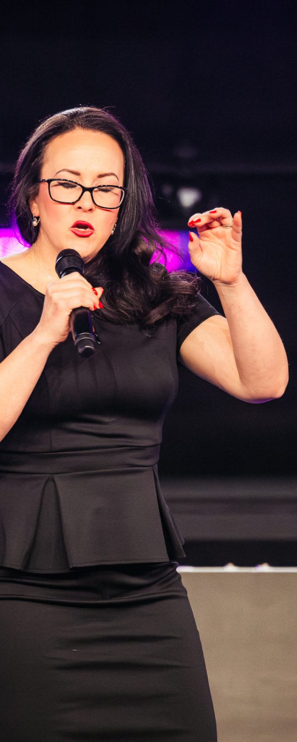 Tara LaFon Gooch on stage delivering a speech on Christian faith
