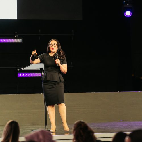 Tara LaFon Gooch on stage delivering a speech on Christian faith